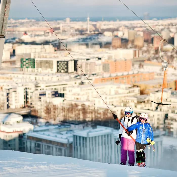 Snowboarding and skiing with a city view